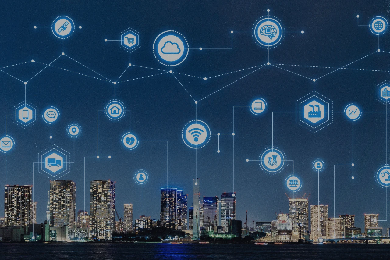 City skyline at night with connected smart city and technology icons.